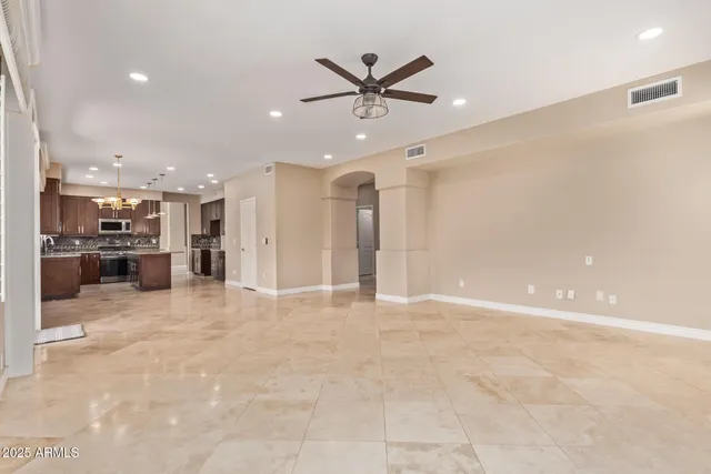 a view of an empty room with a window and kitchen view
