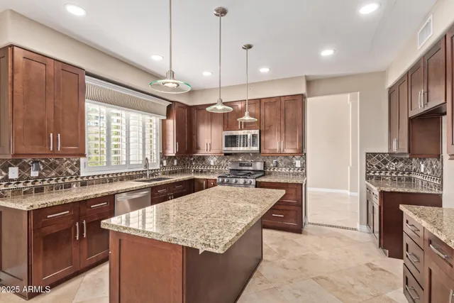 a kitchen with stainless steel appliances granite countertop a sink stove and refrigerator