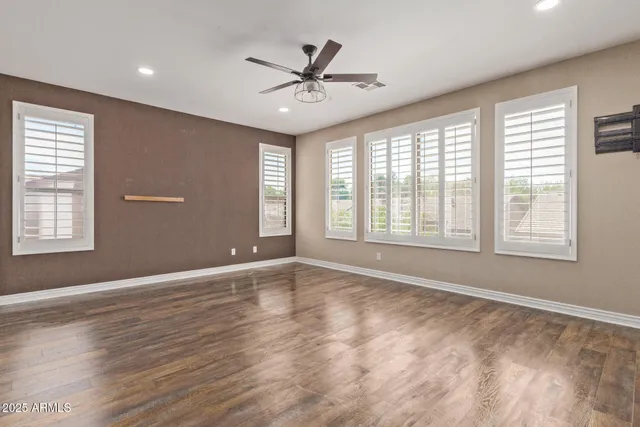 a view of an empty room with a window and wooden floor