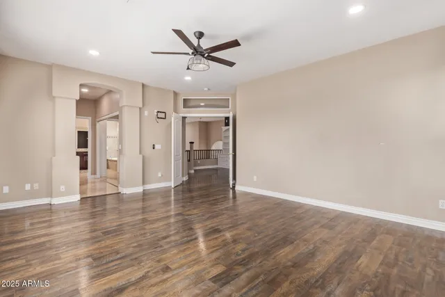 a view of a livingroom with a ceiling fan and wooden floor