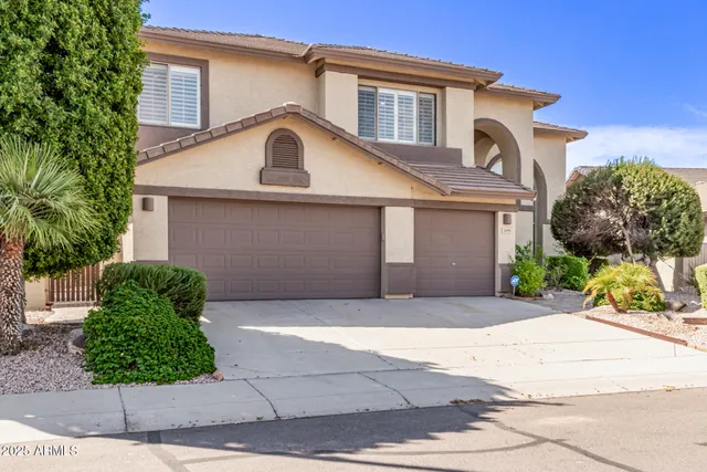 a view of a white house with a yard and plants