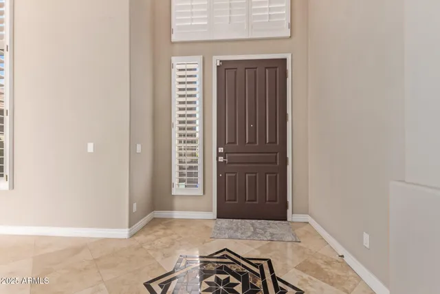 a view of an empty room with a window and a kitchen