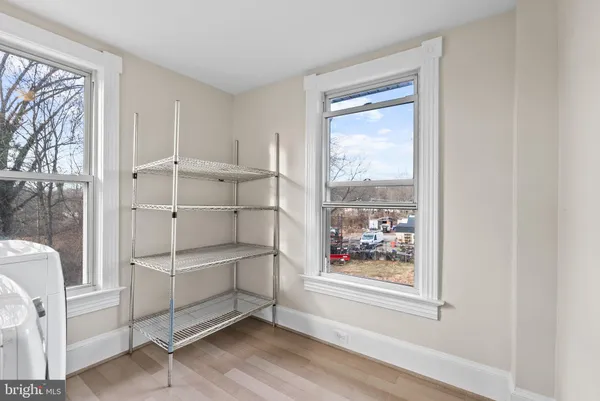 a view of a room with window wooden floor and front door