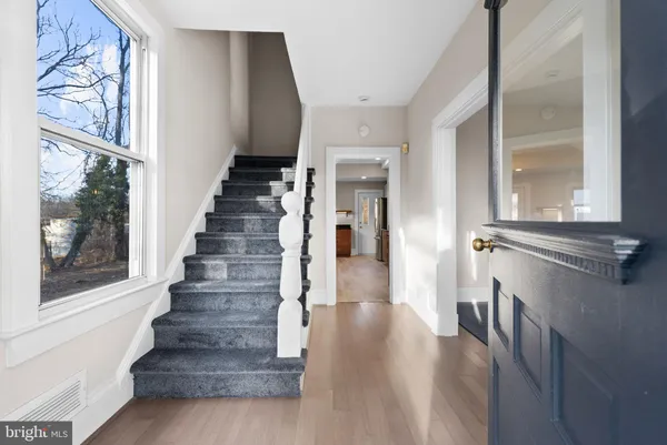 a view of a hallway with wooden floor and windows