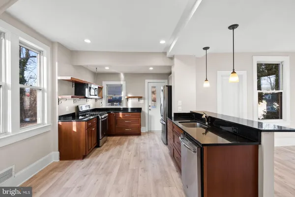 a kitchen with stainless steel appliances granite countertop a sink stove and refrigerator