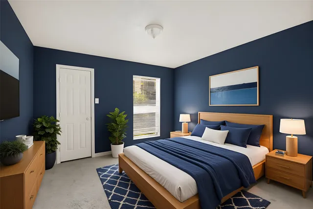 a bedroom with bed and a potted plant