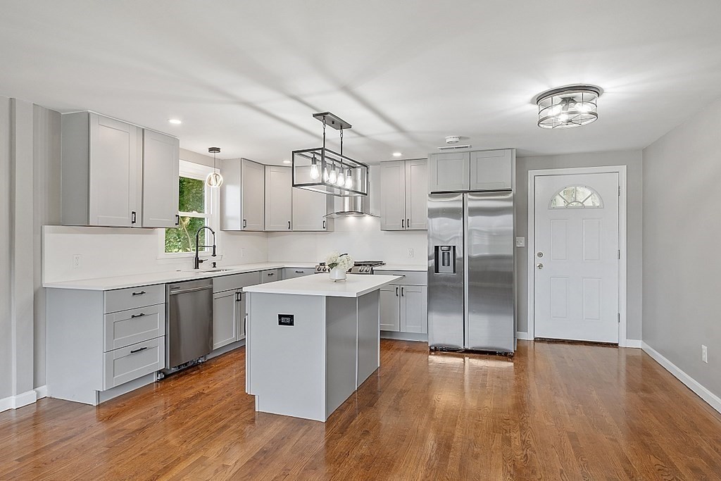 a kitchen with a center island appliances and cabinets