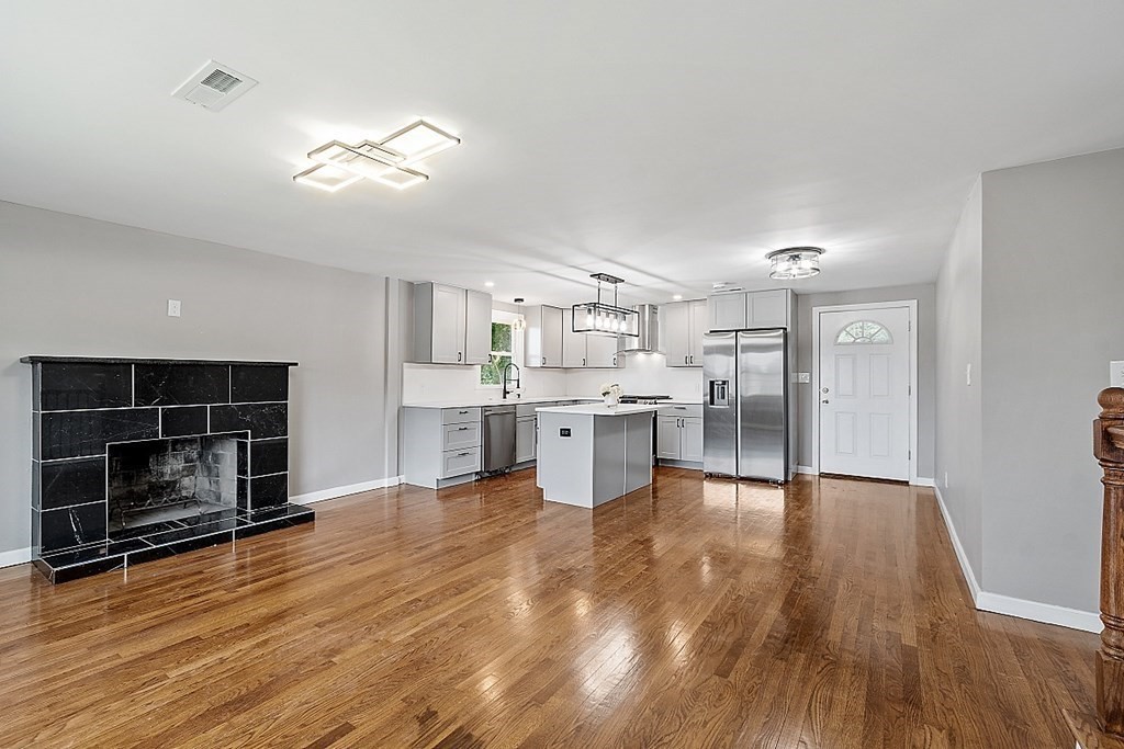 621 Boston Road Billerica, MA 01821 - Photo 4 of 27 a large white kitchen with wooden floors and a fireplace