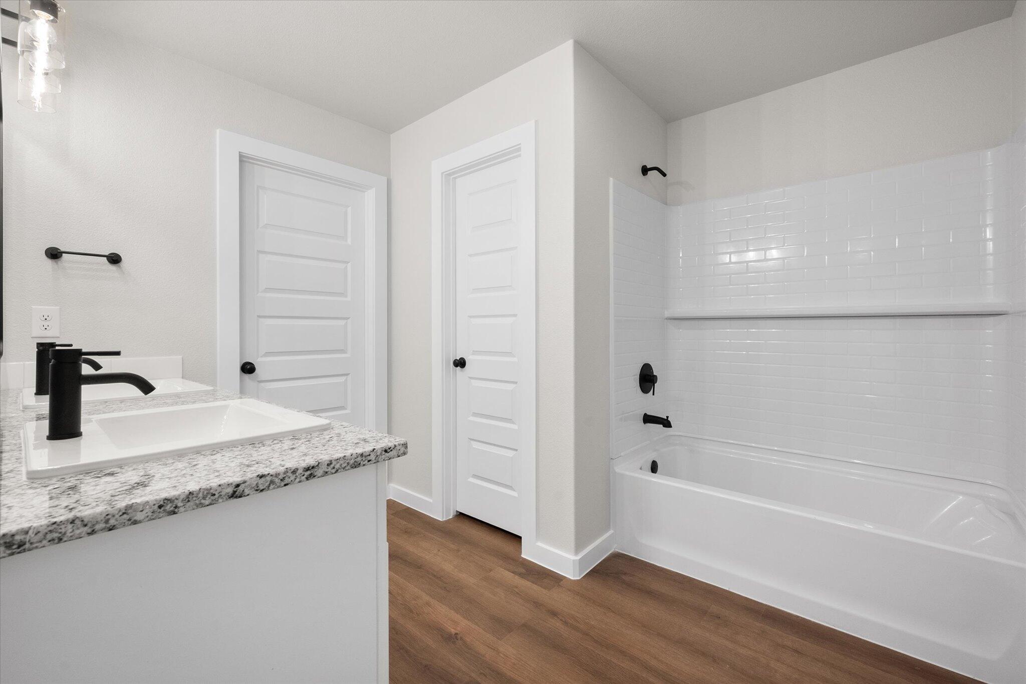 3022 140th Street Lubbock, TX 79423 - Photo 14 of 20 a bathroom with a granite countertop sink a toilet and bathtub
