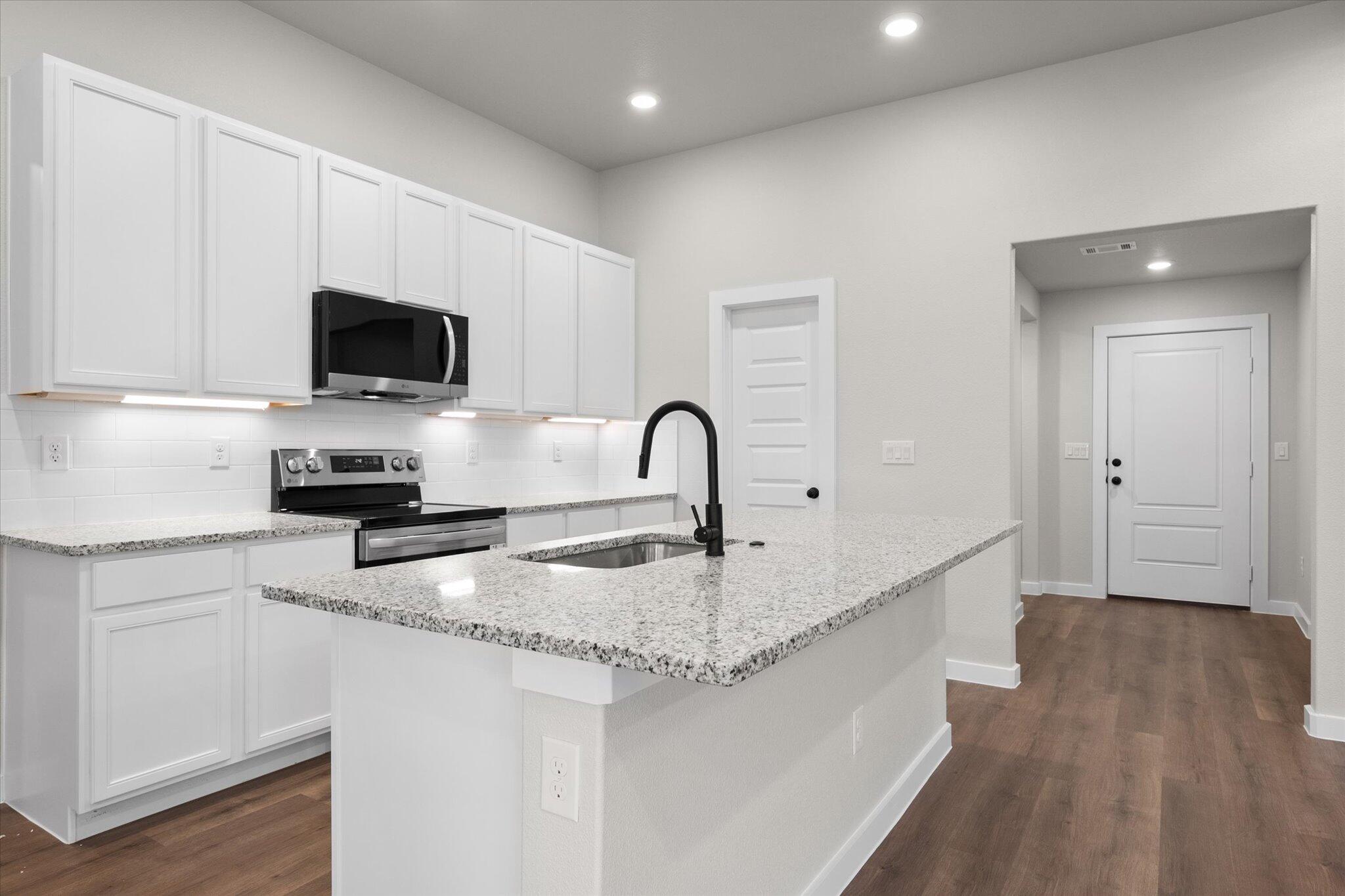 3022 140th Street Lubbock, TX 79423 - Photo 7 of 20 a kitchen with a sink a microwave and cabinets