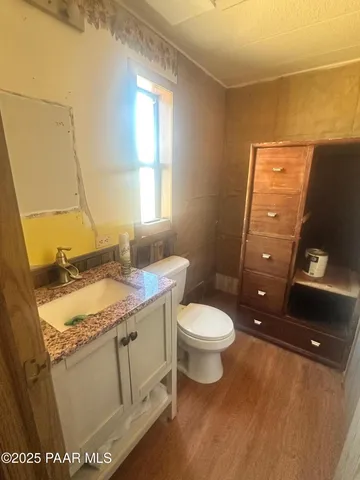 a bathroom with a granite countertop toilet sink and mirror