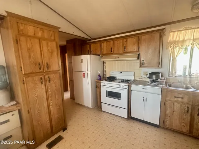 a kitchen with white cabinets and white appliances