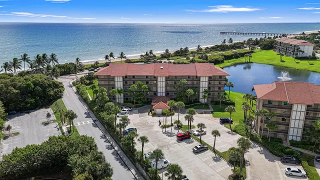 an aerial view of a city with lots of residential buildings ocean and mountain view in back