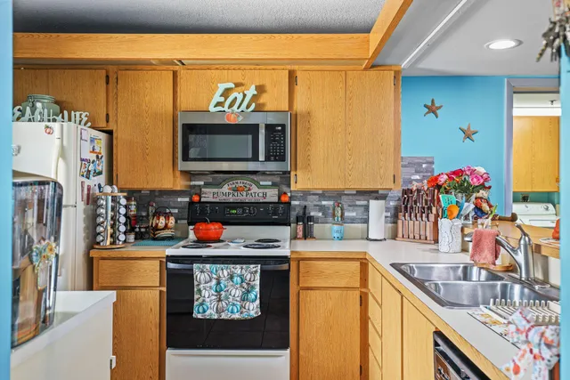 a kitchen with stainless steel appliances a stove a refrigerator sink and a cabinets