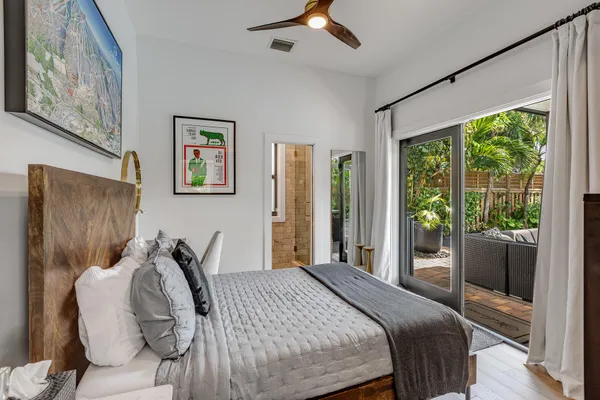 a kitchen with stainless steel appliances a stove top oven a sink dishwasher a dining table and chairs with wooden floor