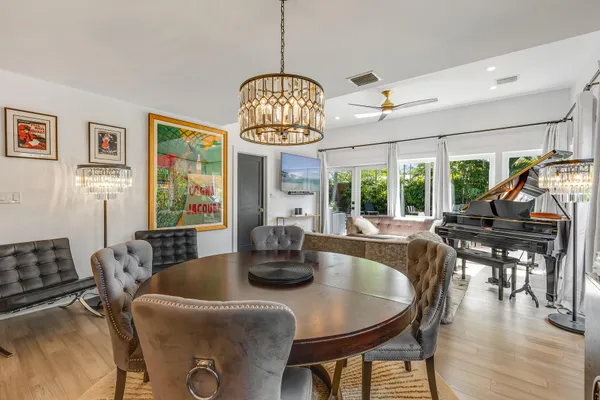 a dining room with furniture a chandelier and wooden floor