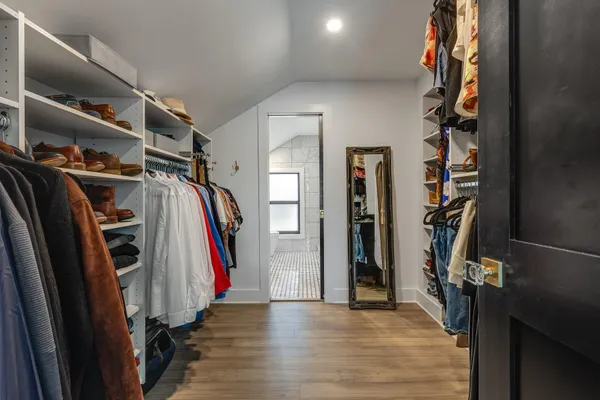 a view of walk in closet with clothes and shoes
