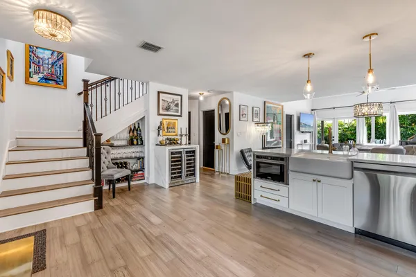 a kitchen with stainless steel appliances granite countertop a refrigerator oven a stove and a dining table with wooden floor