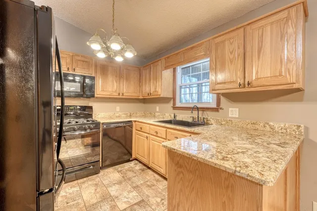 a kitchen with kitchen island granite countertop a sink cabinets and stainless steel appliances