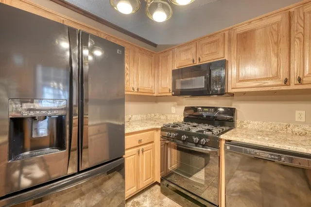 a kitchen with stainless steel appliances granite countertop a stove a sink and a microwave