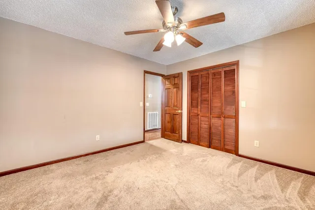 an empty room with chandelier fan