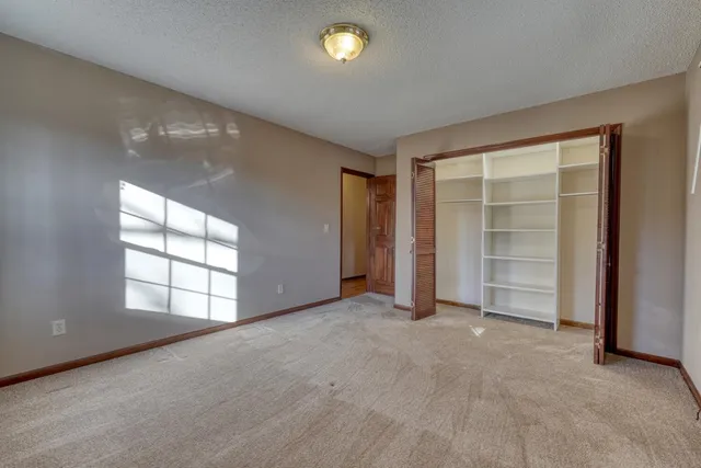 an empty room with windows and closet