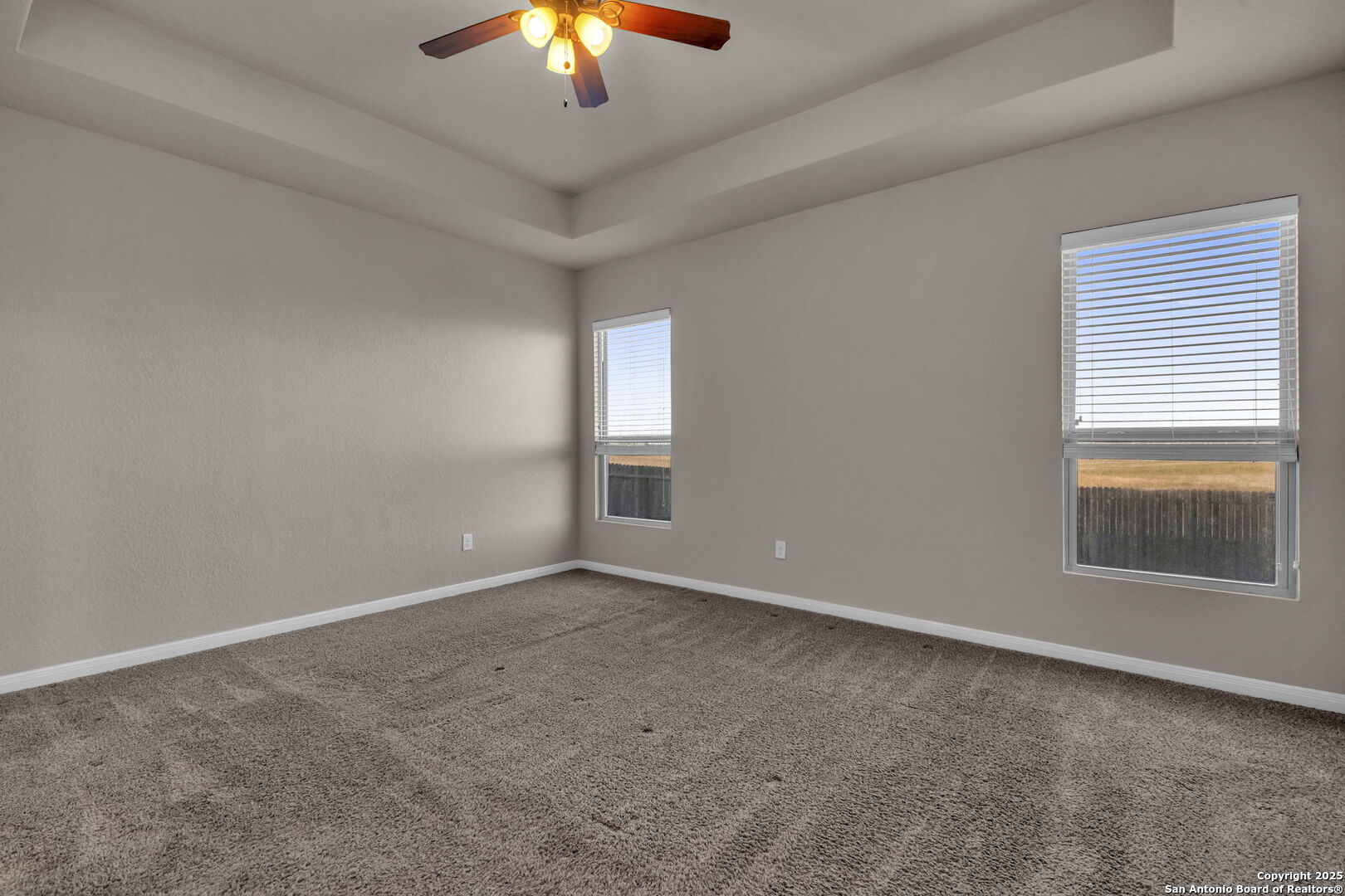 10411 Francisco Way Converse, TX 78109 - Photo 11 of 25 an empty room with a chandelier fan and windows