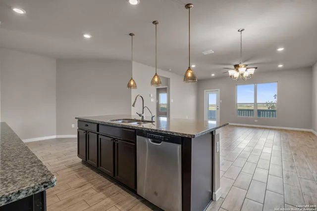 a kitchen with kitchen island a sink appliances and a counter top space