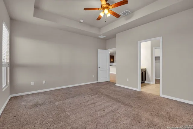 an empty room with closet and a chandelier fan