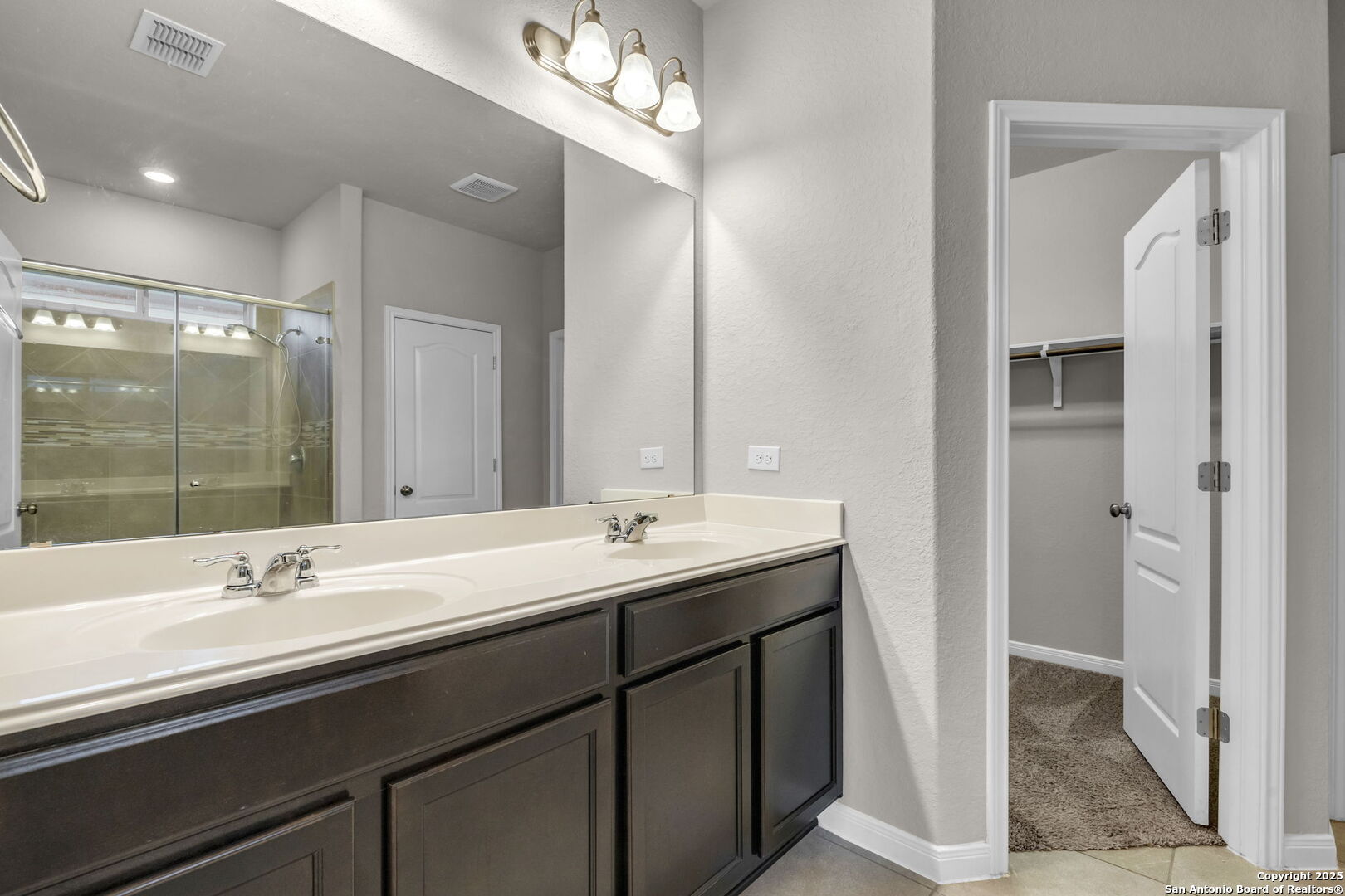 10411 Francisco Way Converse, TX 78109 - Photo 22 of 25 a bathroom with a double vanity sink a mirror and a shower