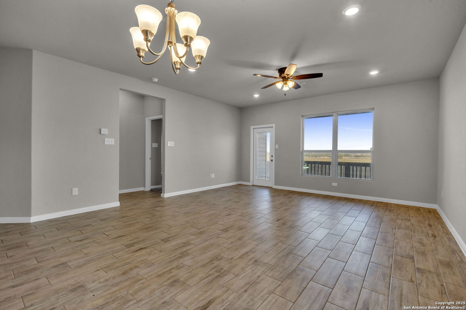 10411 Francisco Way Converse, TX 78109 - Photo 5 of 25 a view of an empty room with a window and wooden floor