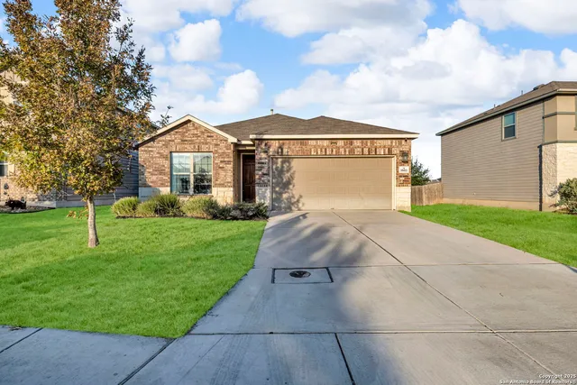 a front view of a house with a yard and trees