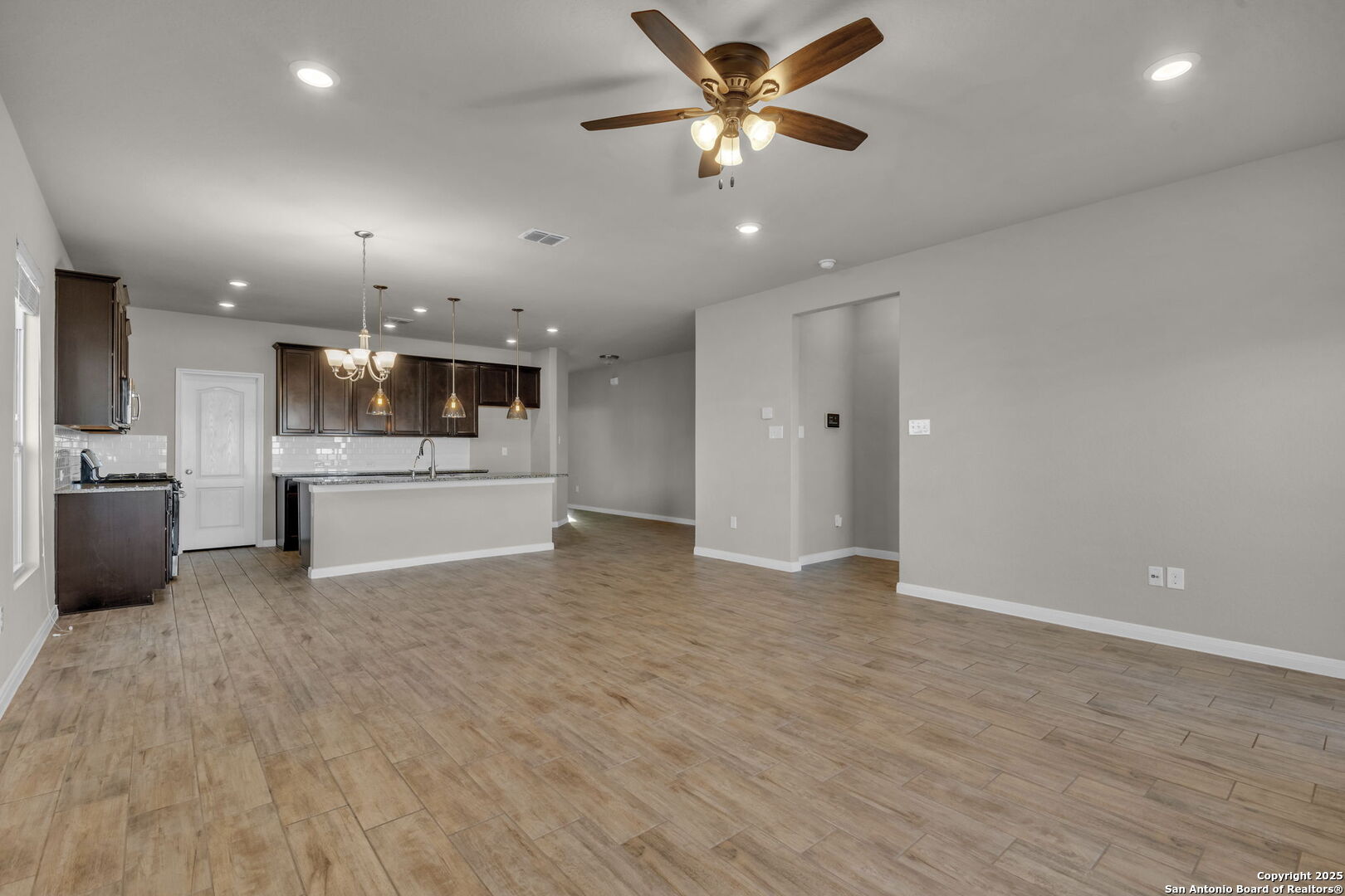 10411 Francisco Way Converse, TX 78109 - Photo 5 of 25 a view of a big room with wooden floor and a kitchen