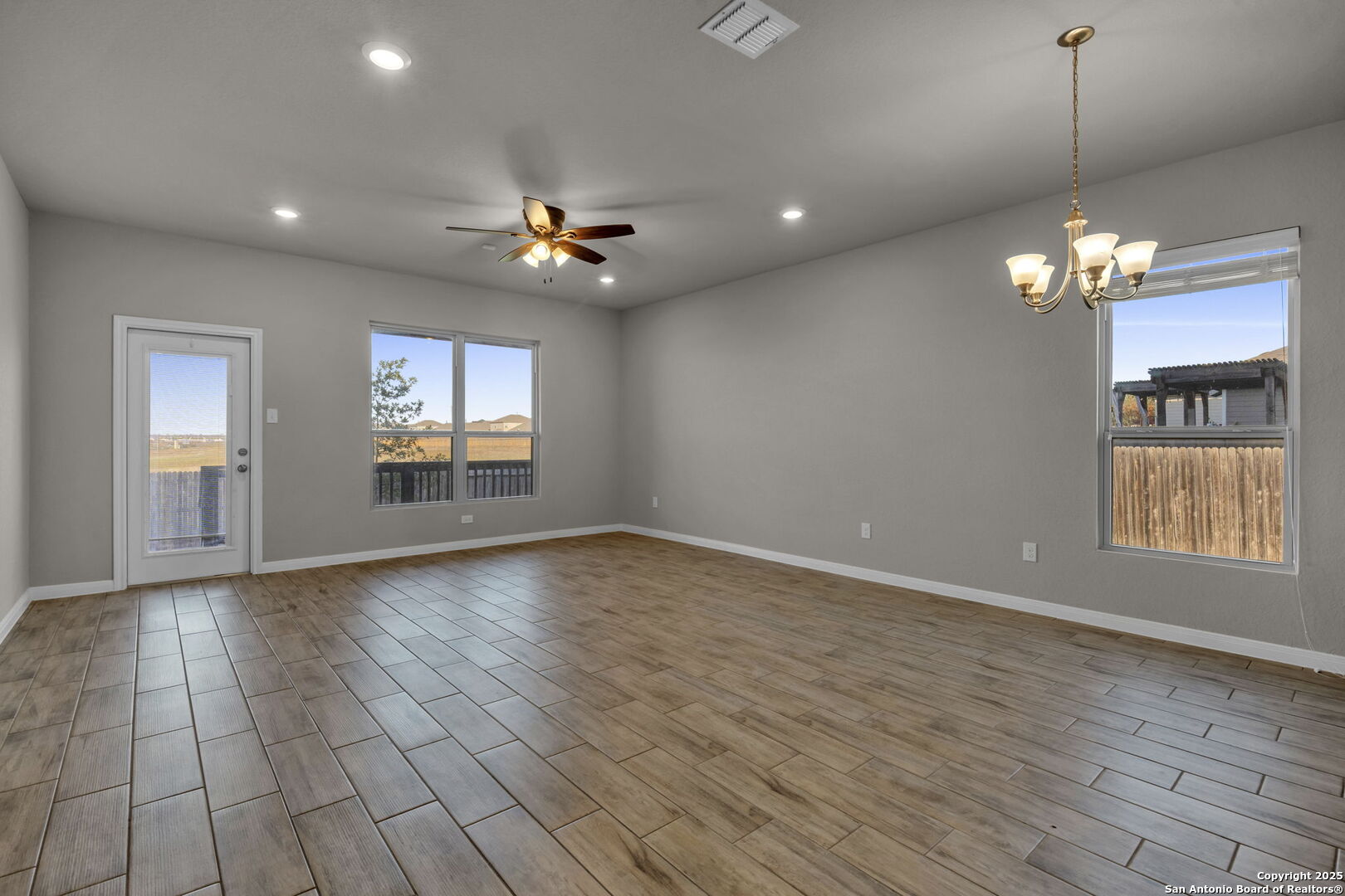 10411 Francisco Way Converse, TX 78109 - Photo 8 of 25 an empty room with wooden floor and windows