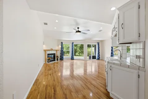 a view of a kitchen with wooden floor and a ceiling fan