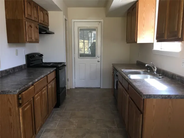 a kitchen with a sink stove and cabinets