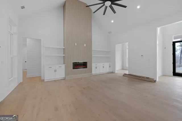 a large white kitchen with kitchen island a sink a center island stainless steel appliances and a counter top space