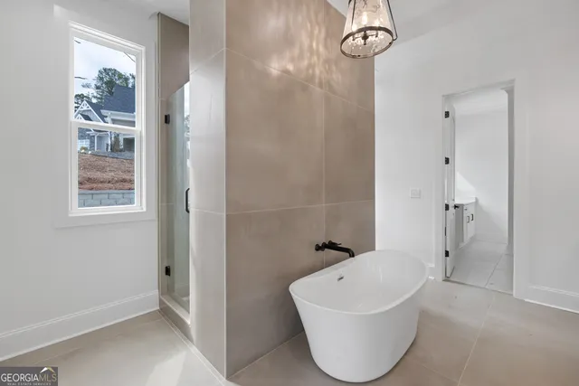 a bathroom with a white tub shower sink and mirror