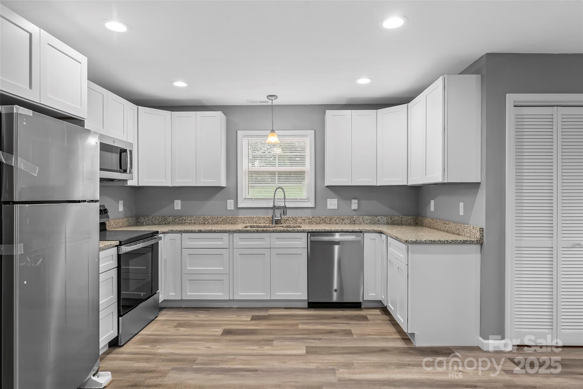 391 Springs East Road Lincolnton, NC 28092 - Photo 11 of 26 a kitchen with stainless steel appliances granite countertop a stove a sink and a refrigerator