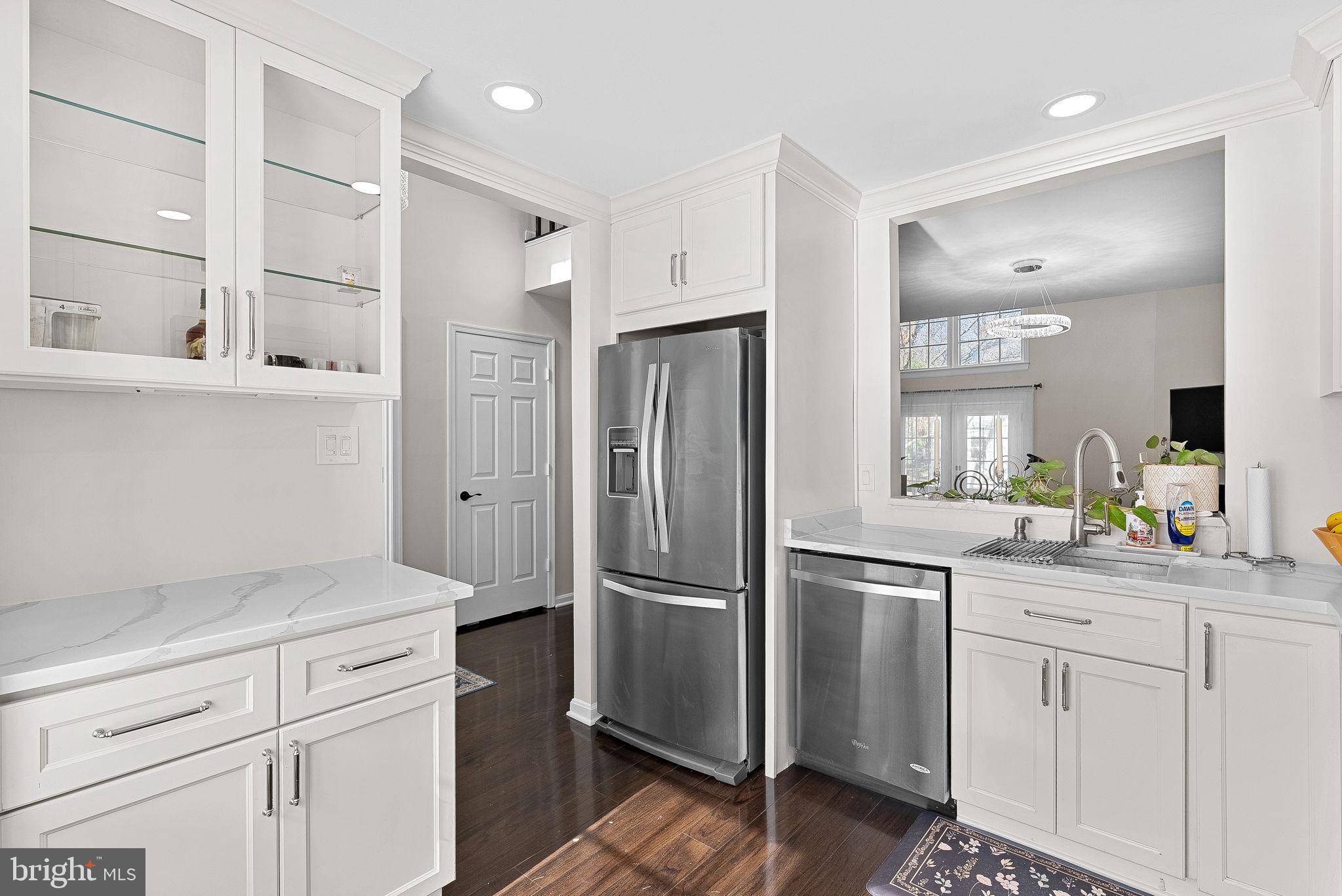 8228 Maple Ridge Avenue Springfield, VA 22153 - Photo 8 of 64 a kitchen with a refrigerator and white cabinets