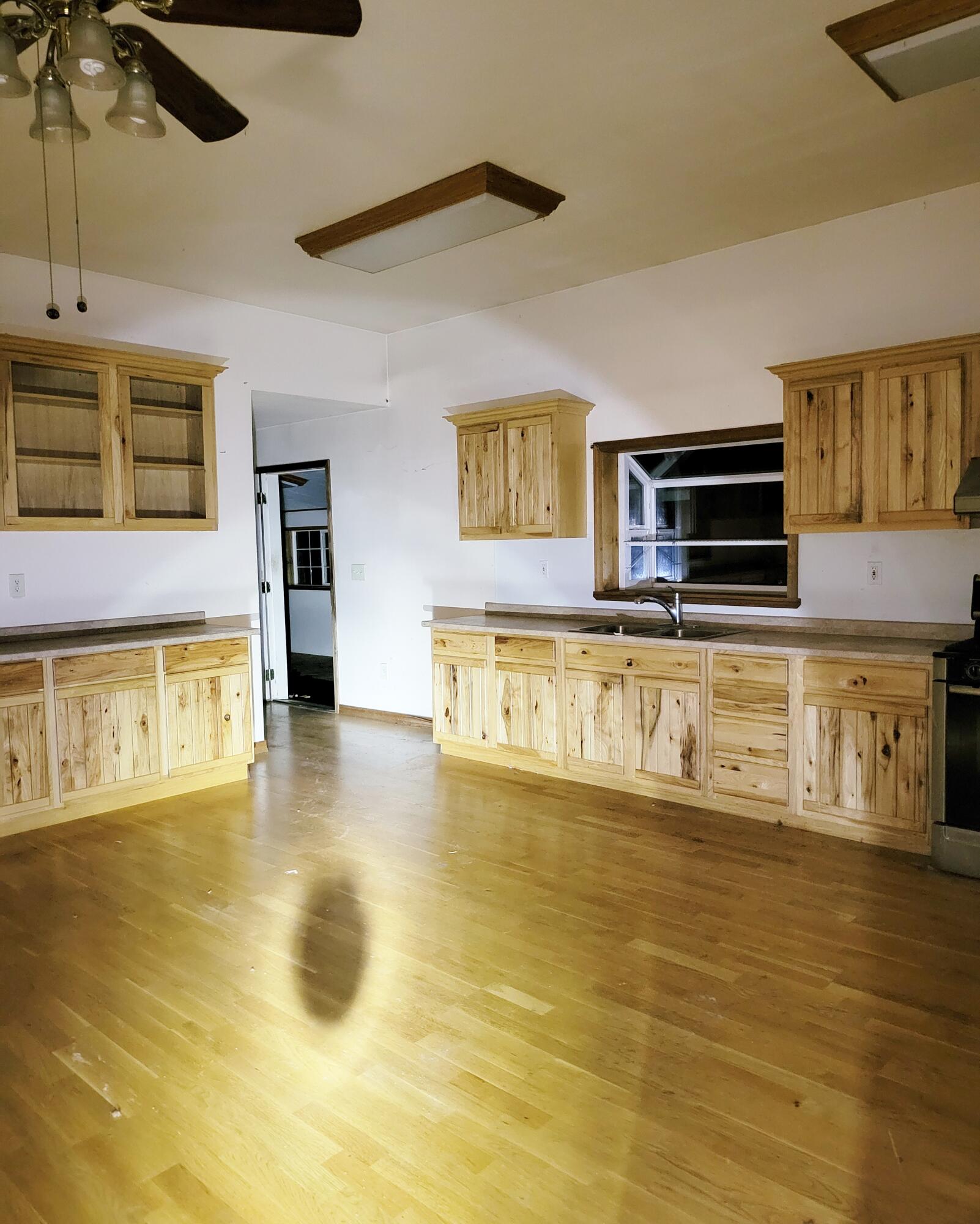 44961 Pine Shadows Road McArthur, CA 96056 - Photo 8 of 25 a view of a kitchen with kitchen island a sink wooden floor and black appliances