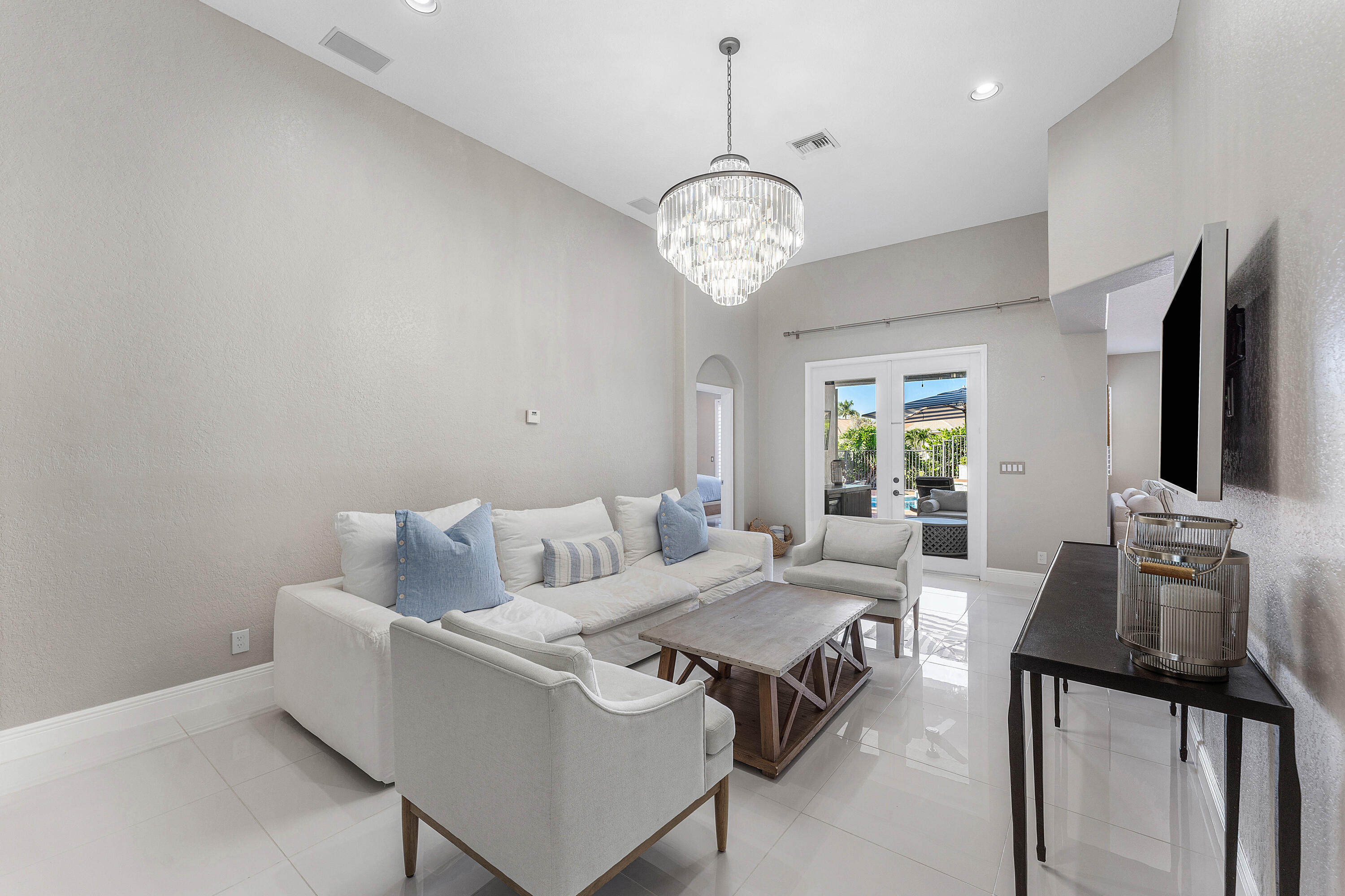 121 Palm Circle Lake Worth, FL 33462 - Photo 19 of 63 a living room with furniture a chandelier and a flat screen tv