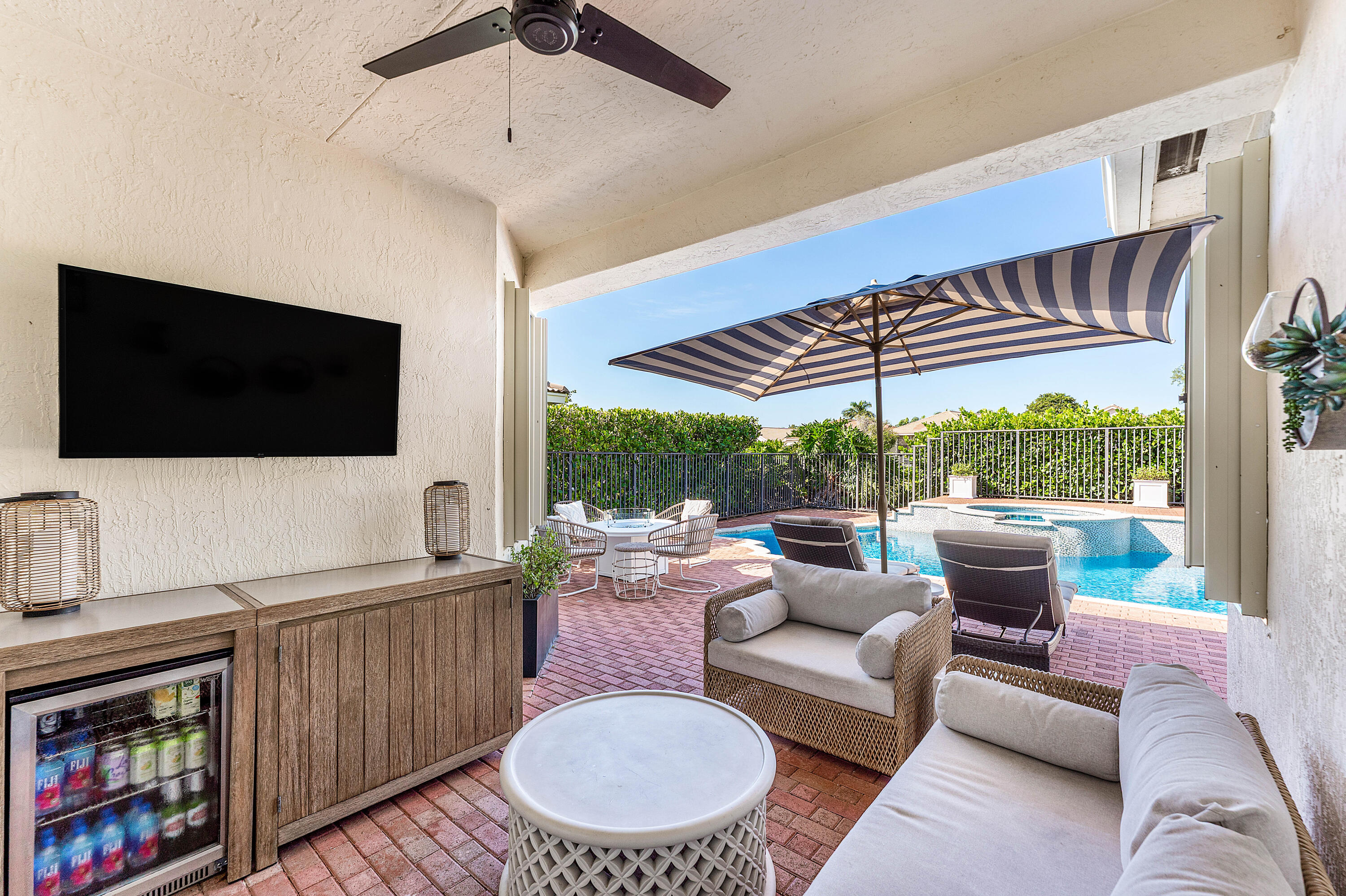 121 Palm Circle Lake Worth, FL 33462 - Photo 37 of 63 a living room with furniture a flat screen tv and a floor to ceiling window