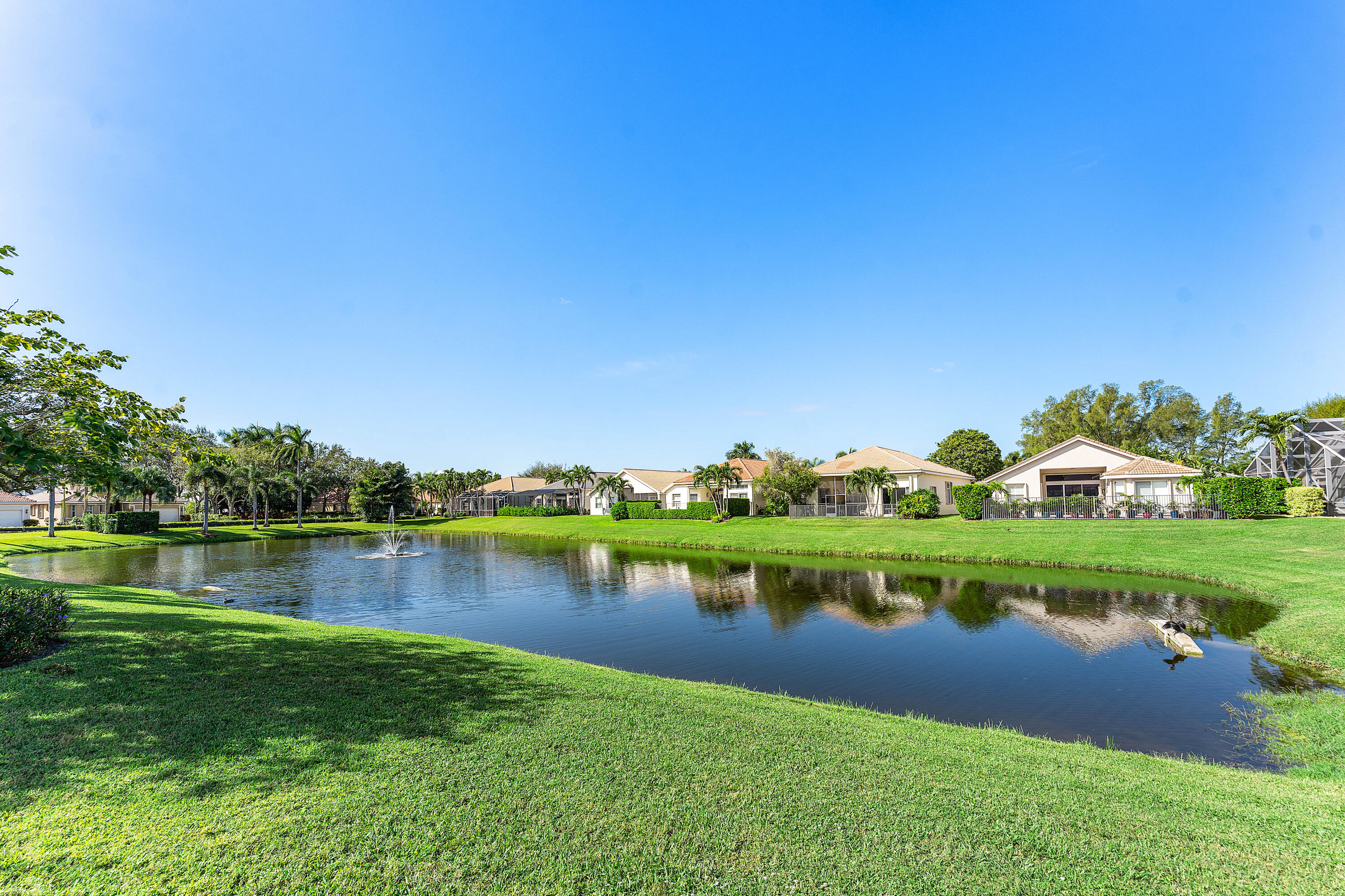 121 Palm Circle Lake Worth, FL 33462 - Photo 46 of 63 a view of a lake with a houses in the background