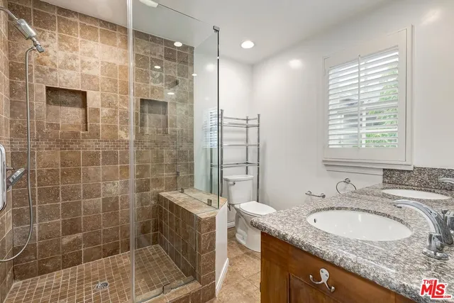 a bathroom with a granite countertop sink a shower and a mirror