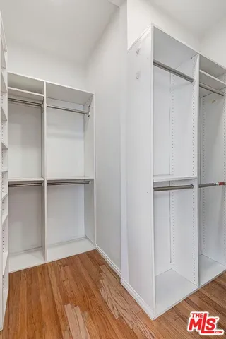 a view of walk in closet with empty racks