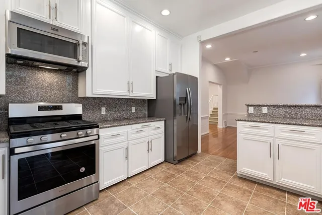 a kitchen with stainless steel appliances granite countertop a stove microwave and refrigerator