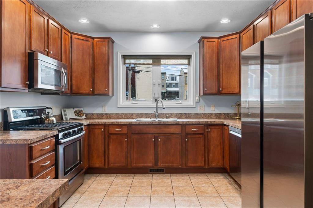 1410 Federal Street Pittsburgh, PA 15212 - Photo 14 of 42 a kitchen with stainless steel appliances granite countertop a stove a sink and a refrigerator