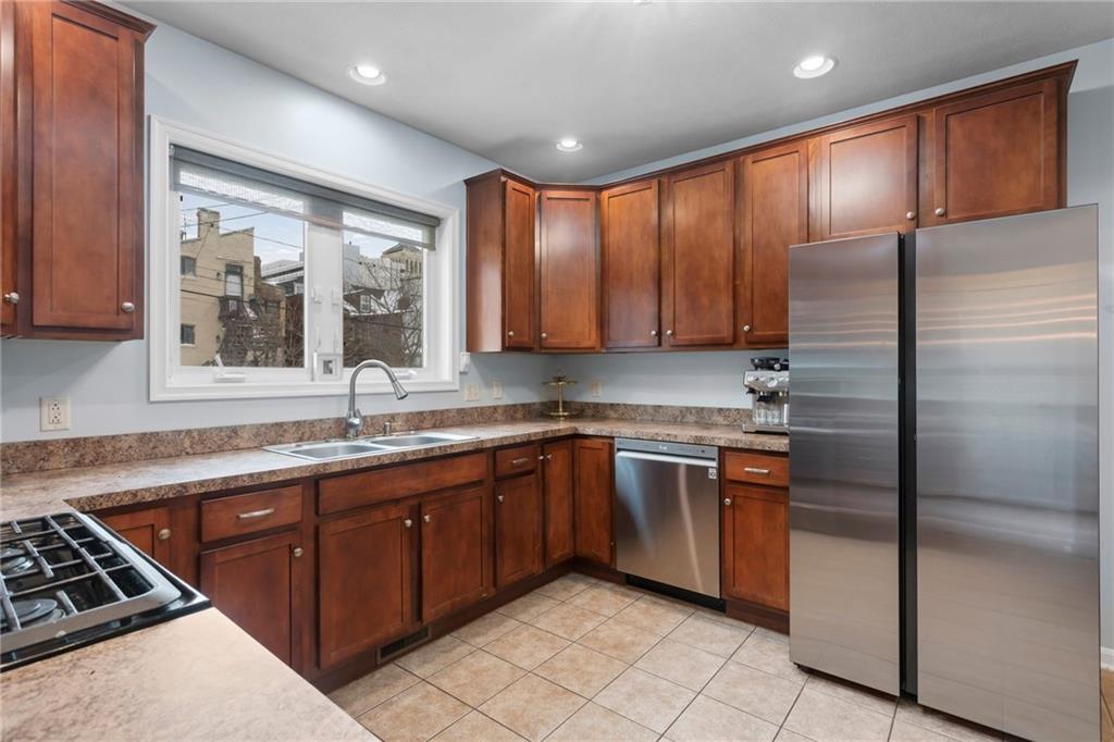 1410 Federal Street Pittsburgh, PA 15212 - Photo 15 of 42 a kitchen with stainless steel appliances granite countertop a stove a sink dishwasher a refrigerator and cabinets with wooden floor