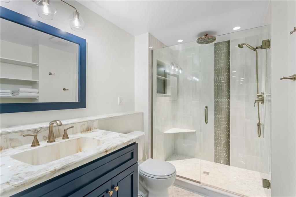 1410 Federal Street Pittsburgh, PA 15212 - Photo 38 of 42 a bathroom with a granite countertop sink a toilet a mirror and shower